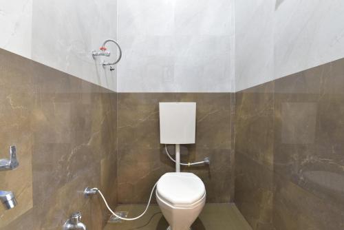 La salle de bains est pourvue de toilettes blanches et d'un lavabo. dans l'établissement Hotel ANGAN, à Udaipur