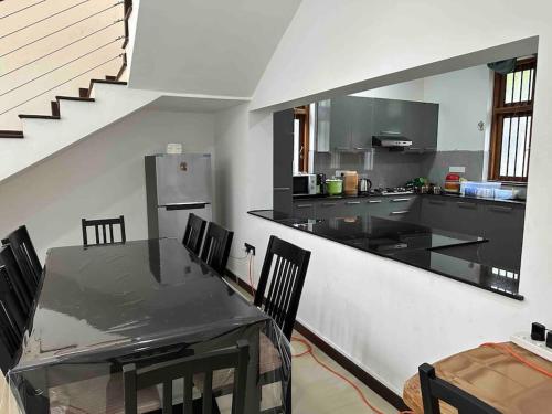 a kitchen with a table and chairs and a counter at Beauty World Villa - Gampaha in Gampaha