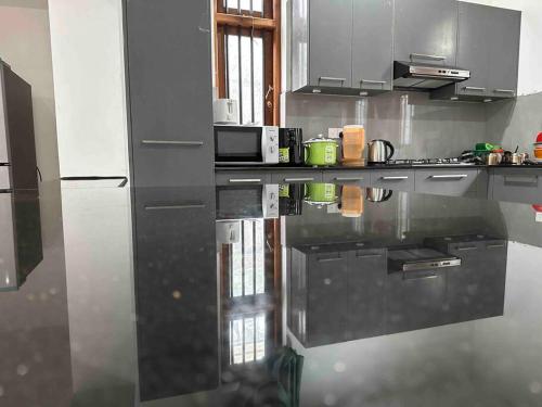 a kitchen with a black counter top in a kitchen at Beauty World Villa - Gampaha in Gampaha