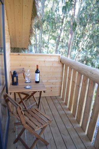 a wooden deck with a table and a bottle of wine at MountView in Alenquer