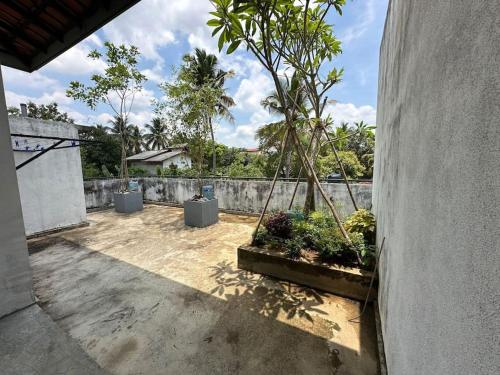 a courtyard with trees and plants in a fence at Beauty World Villa - Gampaha in Gampaha
