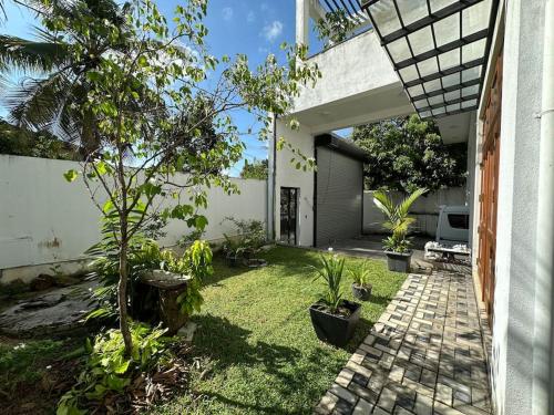 a garden with a pathway leading to a house at Beauty World Villa - Gampaha in Gampaha