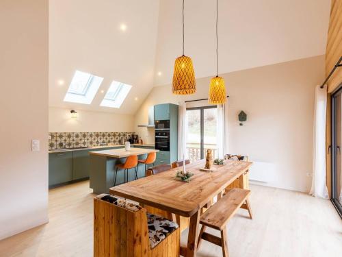 une cuisine et une salle à manger avec une table et des chaises en bois dans l'établissement Maison d’exception 8 pers avec WiFi, garage sécurisé et linge inclus près de Loudenvielle - FR-1-695-47, à Loudenvielle