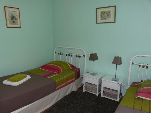 Un dormitorio con dos camas y dos mesitas de noche. en Gîte de la Tuilerie, en Ardelu