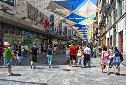 una multitud de personas caminando por una calle de la ciudad en Habitación Callao, en Madrid