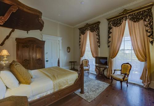a bedroom with a large bed and a television at The Inn at Cedar Grove in Vicksburg