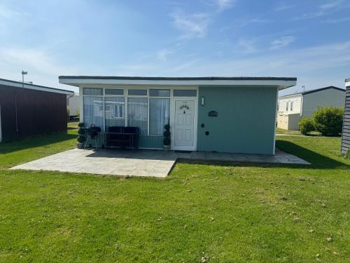 a green shed with a door and a patio at K238, Pequeno Castelo in Camber