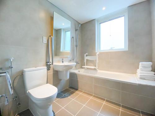 La salle de bains est pourvue de toilettes, d'une baignoire et d'un lavabo. dans l'établissement Comfy 1BR in Damac Maison Prive by Huaxia Homes, à Dubaï