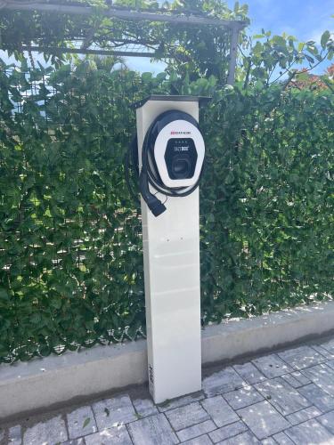 a parking meter sitting in front of a bush at Villa Betty Apartments in Arco