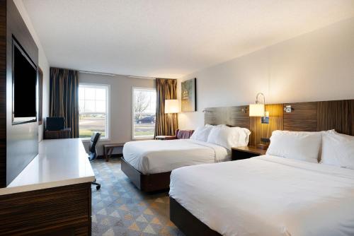 um quarto de hotel com duas camas e uma secretária em Redwood Lodge em Redwood Falls