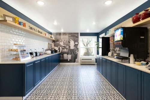 a kitchen with blue cabinets and a tile floor at Redwood Lodge in Redwood Falls