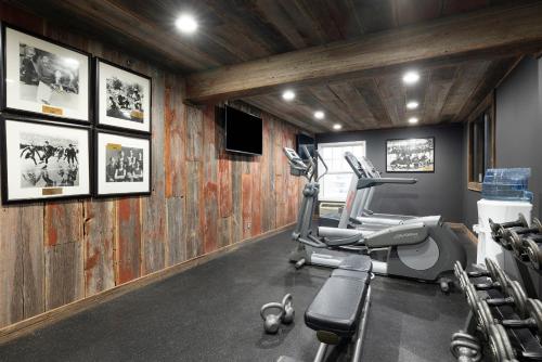 a gym with tread machines in a room with wooden walls at Redwood Lodge in Redwood Falls