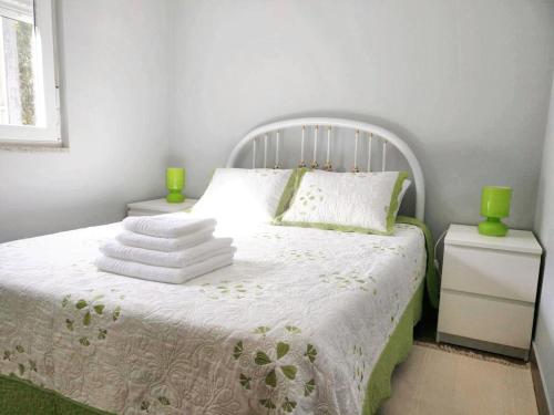 um quarto com uma cama branca com vasos verdes em 2 bedrooms house with lake view enclosed garden and wifi at Rendufe em Rendufe