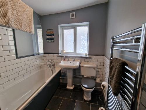 a bathroom with a sink and a toilet and a tub at Cottage in the Heart of Brixham in Brixham
