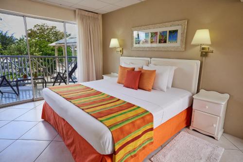 um quarto com uma cama e uma varanda em Southern Surf Beach Apartments em Bridgetown