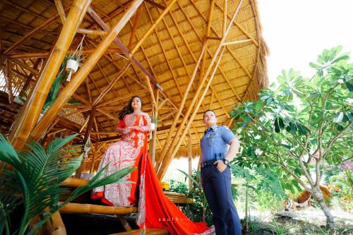 a woman in a red dress standing next to a man at Tongo Hill Cottages in Moalboal