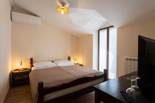 a bedroom with a bed and a table and a tv at Guest House Valentincic in Nova Gorica