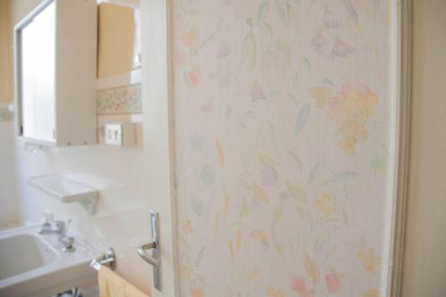 La salle de bains est pourvue d'un rideau de douche et de fleurs. dans l'établissement Smart AC apartament close sea downtown Great Stay, à Nice