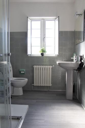 a bathroom with a sink and a toilet and a window at Casa A Gateira in O Casal Pontevedra