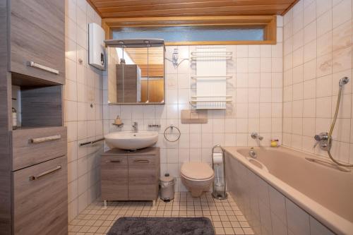 a bathroom with a sink and a toilet and a tub at Haus Moselwelt - Tilda in Zell an der Mosel