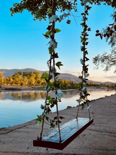 a plant is growing in a wooden frame next to a river at Drinski kej in Zvornik