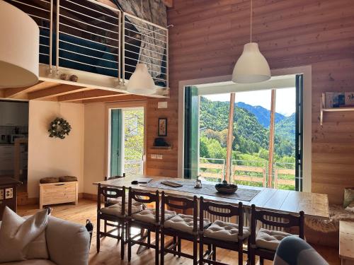 a dining room with a table and a large window at CIELO E TERRA Chalet Zencheri con vista panoramica in Piazza