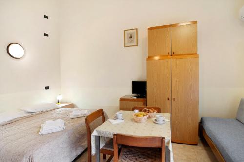 a room with a bed and a table and a bed at Monolocale La Pineta 46 in Albenga