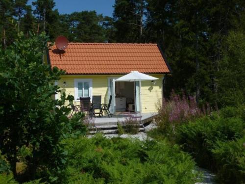 una pequeña casa amarilla con techo rojo en Kleines Ferienhaus - Tiny house - auf Gotland 700 Meter zum Meer en Ljugarn