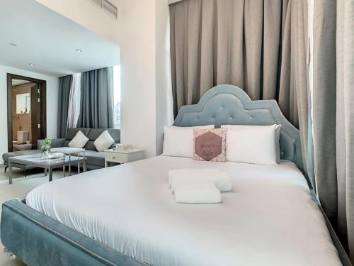 1 dormitorio con 1 cama grande y cabecero azul en Key View - Hilliana Tower en Dubái
