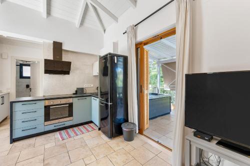 a kitchen with blue cabinets and a tv in a room at Villa Semipuella in Agios Nikitas