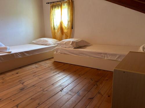 two beds in a room with a wooden floor at Dreams Apartments - Katelios,Santa Barbara beach in Katelios