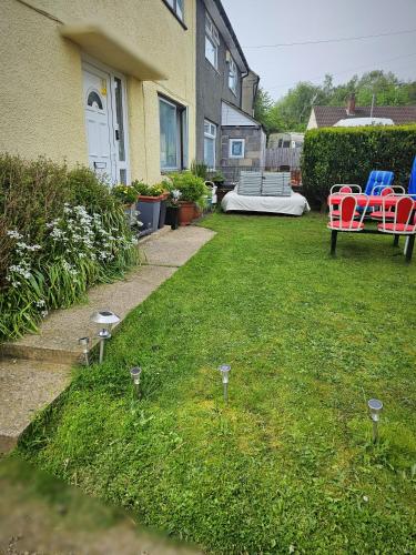 オラートンにあるCuisineaseの芝生の中に赤青の椅子が置かれた庭