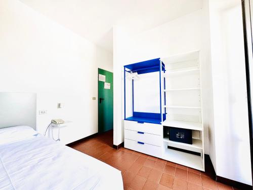 a white bedroom with a bed and a mirror at Hotel Blumen in San Benedetto del Tronto