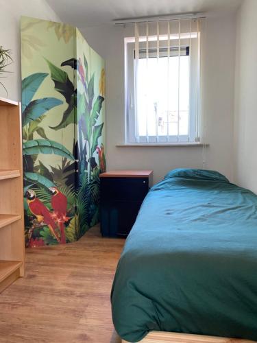 a bedroom with a green bed and a window at Woning met 4 slaapkamers in Zelzate