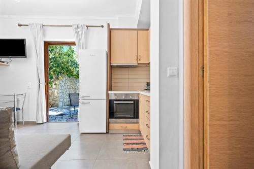 a kitchen with a white refrigerator and a stove at Villa Semipuella in Agios Nikitas
