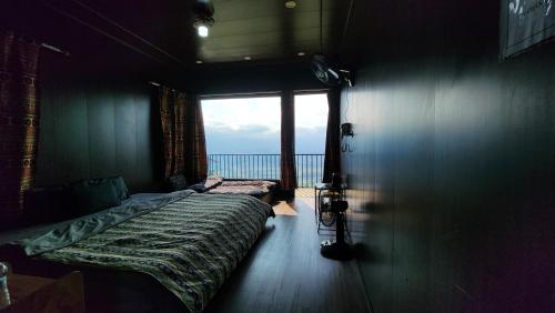um quarto com uma cama e vista para o oceano em Lau Camping Phình Hồ em Yên Bái
