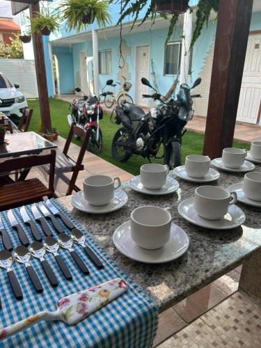 a table with cups and saucers on top of it at Pousada Recanto Itaúnas in Itaúnas