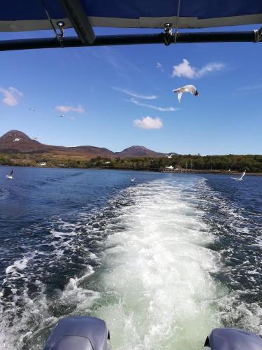 a view from the back of a boat on a lake at The guest wing at kylemore house in Kylemore