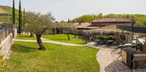 a green yard with a tree and a building at Guest House Valentincic in Nova Gorica