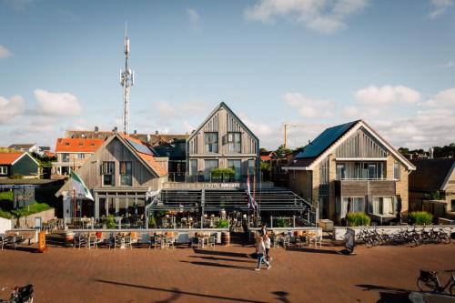 um edifício com pessoas a andar na frente dele em Stuifdijk em Oost-Vlieland