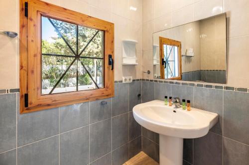 ein Bad mit einem Waschbecken und einem Fenster in der Unterkunft Casa Aalaya: Ibiza Mediterranean Retreat in Illes Balears