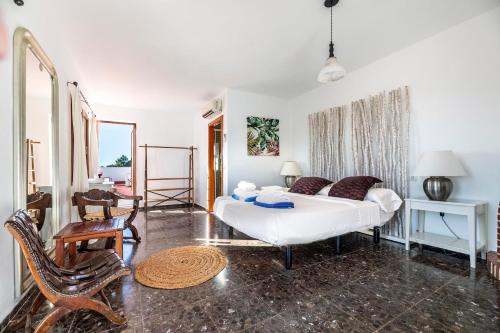 a living room with a white bed and a chair at Casa Aalaya Ibiza Mediterranean Retreat in Illes Balears