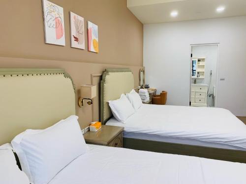 two beds in a room with white sheets at Good Times BnB in Chishang