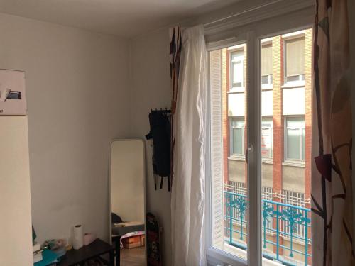 une pièce avec une fenêtre et un réfrigérateur à côté dans l'établissement Paris12, à Paris