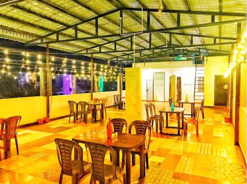 a restaurant with wooden tables and chairs and lights at New green hotel in Yelagiri