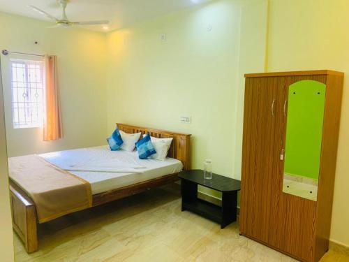a small bedroom with a bed and a table at New green hotel in Yelagiri