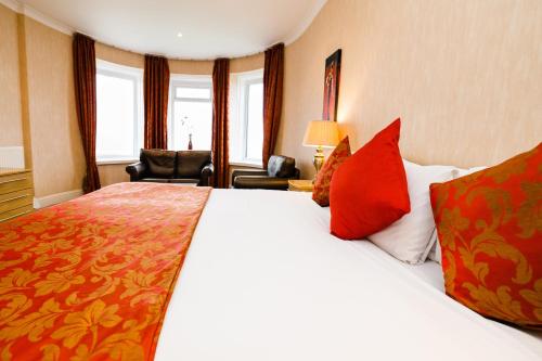 a hotel room with a large bed with red pillows at Raven Hall Hotel in Ravenscar