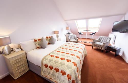 a bedroom with a large bed and a living room at Raven Hall Hotel in Ravenscar
