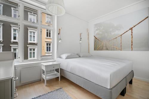 a bedroom with a bed and a bridge painting on the wall at Your Local Bergen Dream In The Heart Of The city in Bergen