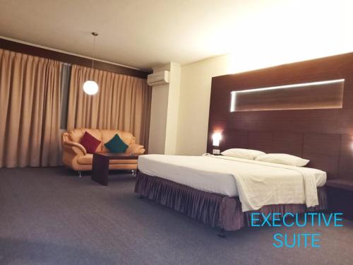 um quarto de hotel com uma cama e uma cadeira em A' Bahtera Residence em Klandasan Kecil